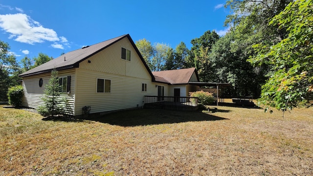 view of home's exterior with a lawn and a wooden deck