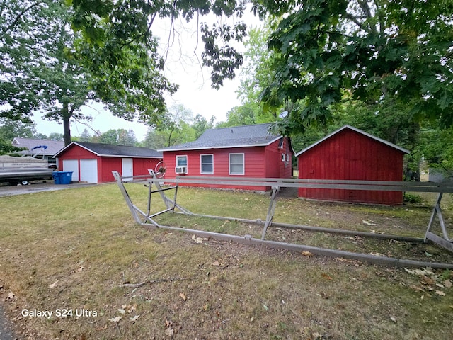 view of front facade featuring an outbuilding, a garage, and a front yard