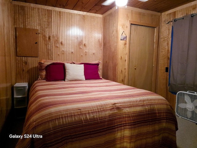 bedroom with wooden ceiling, wooden walls, ceiling fan, and a closet