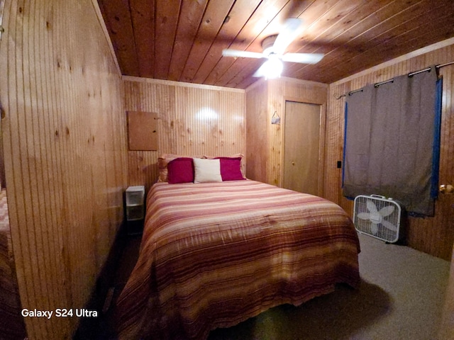 bedroom with ceiling fan, wood walls, and wooden ceiling