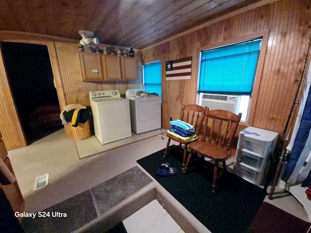 laundry room featuring cooling unit, wooden walls, cabinets, wooden ceiling, and separate washer and dryer