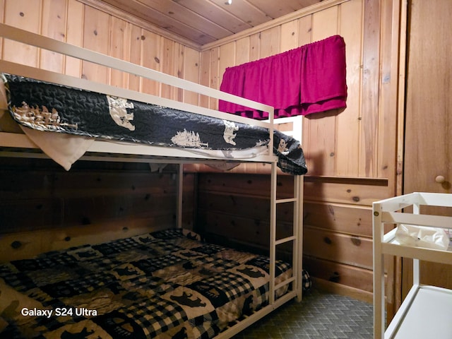 bedroom featuring wooden ceiling and wooden walls