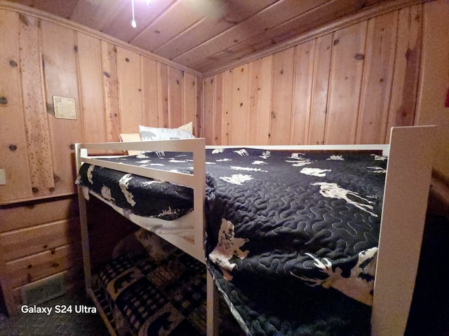 bedroom with wooden ceiling and wood walls