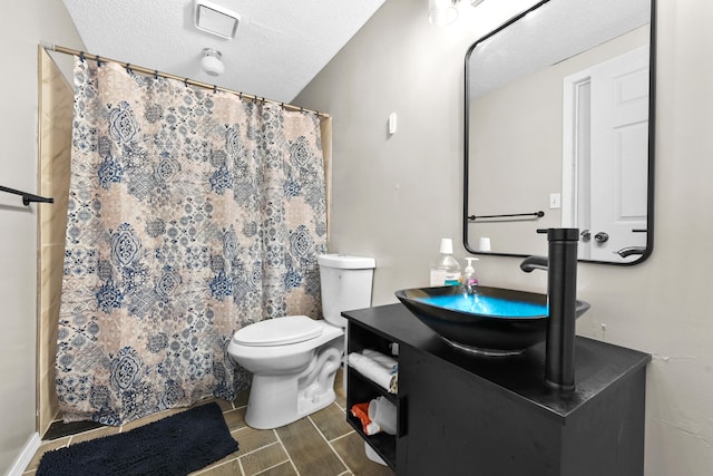 bathroom featuring a textured ceiling, vanity, toilet, and a shower with curtain