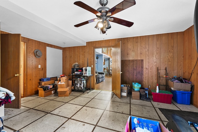 misc room with ceiling fan and wooden walls