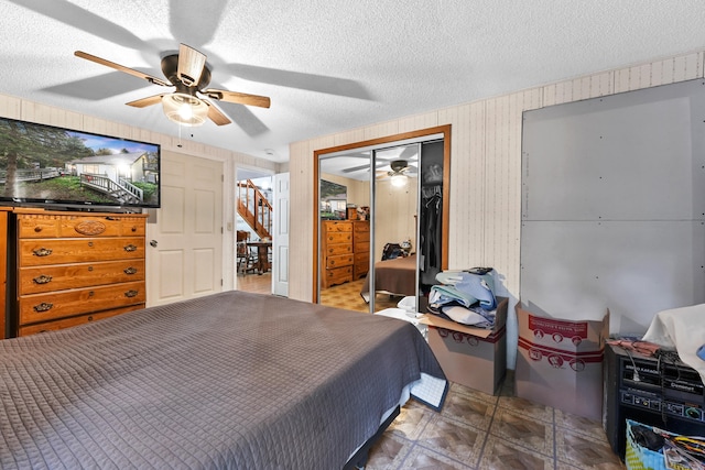 bedroom with a textured ceiling, ceiling fan, and a closet