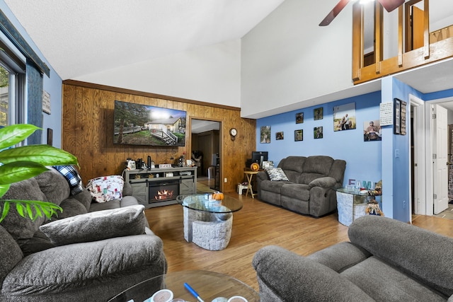 living room featuring high vaulted ceiling, a fireplace, ceiling fan, and hardwood / wood-style flooring