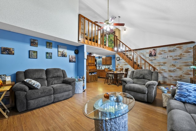 living room with high vaulted ceiling, light wood-type flooring, and ceiling fan