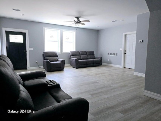 living room featuring light hardwood / wood-style floors and ceiling fan