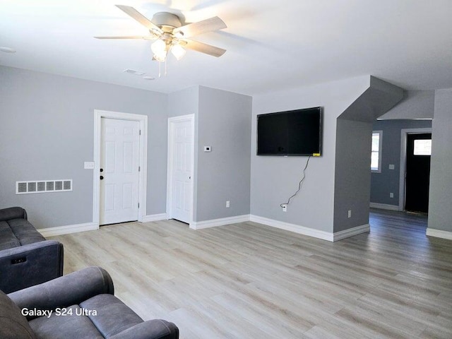 living room with light hardwood / wood-style floors and ceiling fan