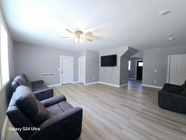 living room with light wood-type flooring and ceiling fan