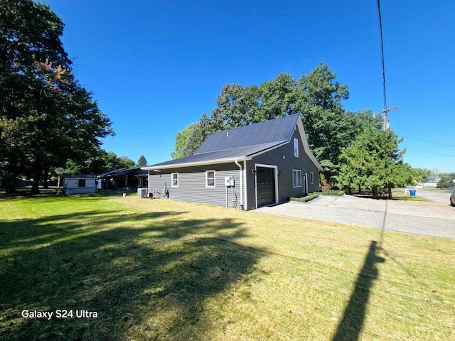 view of side of home featuring a lawn and a garage