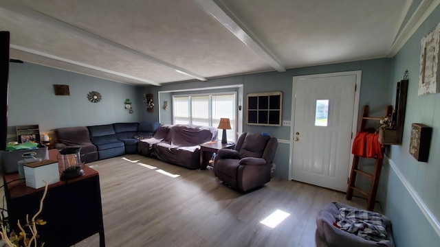 living room with light hardwood / wood-style flooring and beamed ceiling