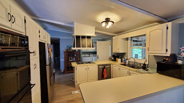 kitchen with washer and dryer, sink, white cabinetry, kitchen peninsula, and stainless steel appliances