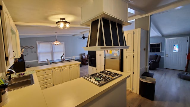 kitchen featuring kitchen peninsula, decorative light fixtures, dark wood-type flooring, stainless steel appliances, and lofted ceiling with beams