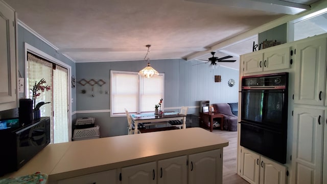 kitchen with lofted ceiling with beams, ceiling fan with notable chandelier, kitchen peninsula, hanging light fixtures, and black double oven