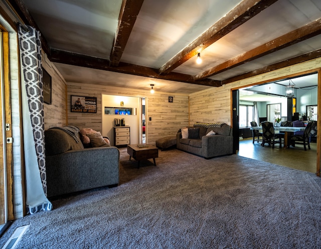 living room with wood walls and beam ceiling