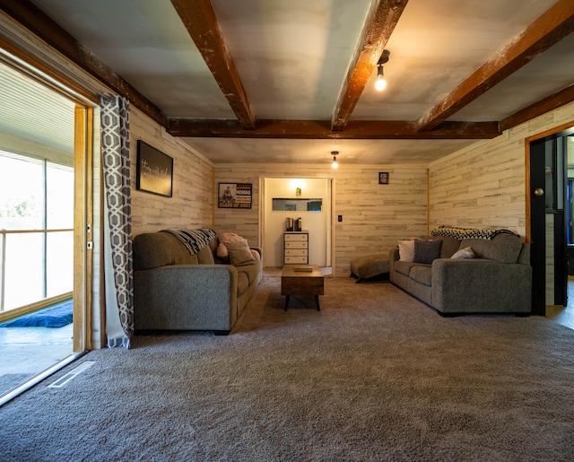 carpeted living room with wooden walls and beam ceiling