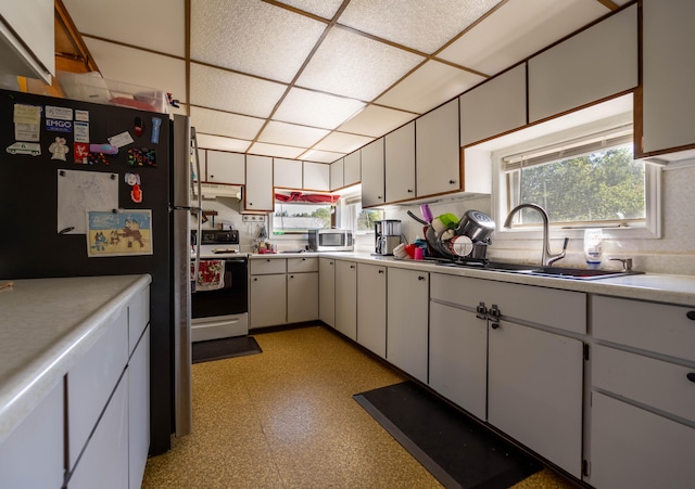 kitchen featuring white cabinets, appliances with stainless steel finishes, sink, and a paneled ceiling