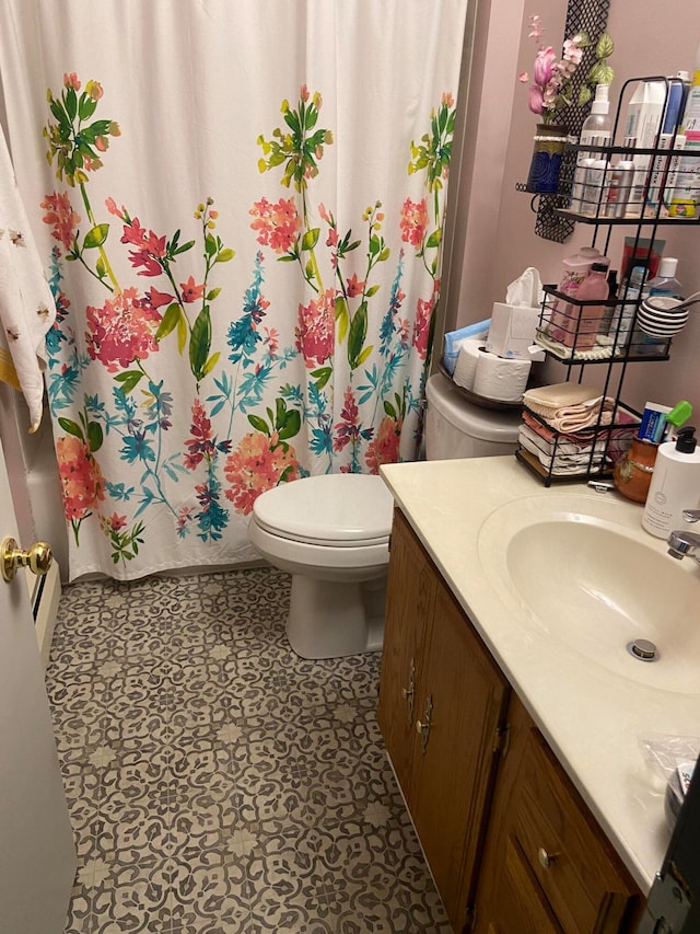 bathroom featuring vanity, toilet, and curtained shower