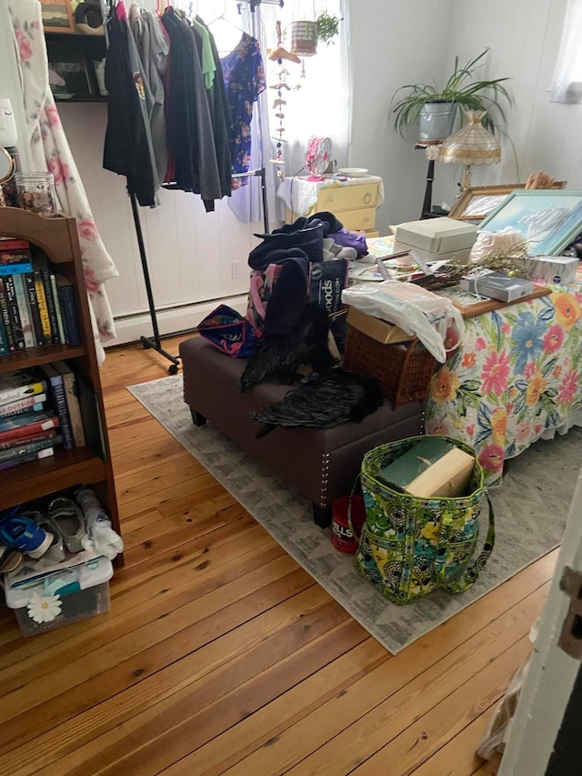 interior space with a baseboard radiator and hardwood / wood-style flooring