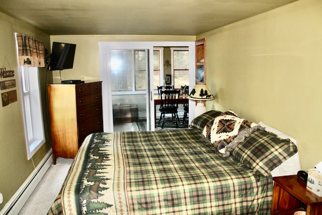 bedroom featuring multiple windows, baseboard heating, and carpet floors