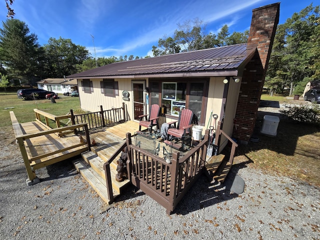 rear view of house with a wooden deck and a yard