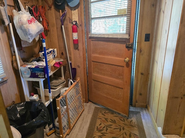 entryway with light wood-type flooring and wood walls