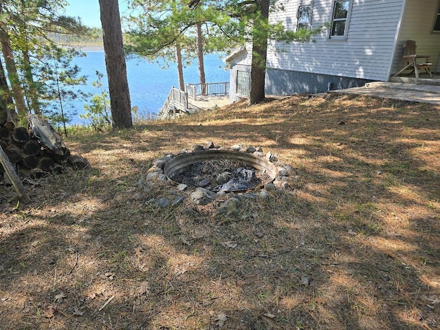 view of yard featuring a water view and an outdoor fire pit