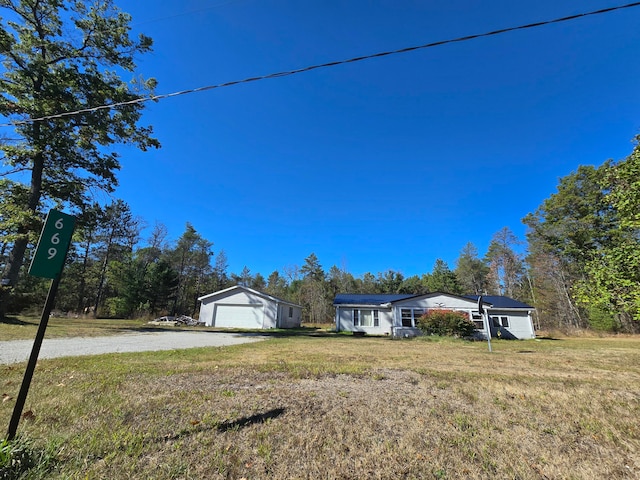 view of front of house with an outdoor structure, a garage, and a front yard