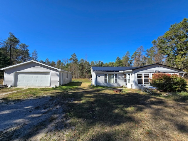 view of front of house with a front yard, an outdoor structure, and a garage