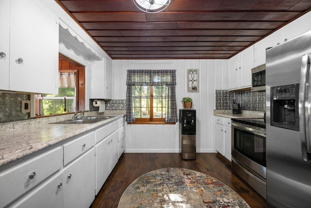 kitchen with white cabinetry, backsplash, appliances with stainless steel finishes, and dark wood-type flooring