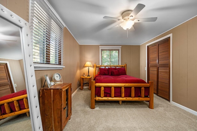 carpeted bedroom with ceiling fan and wooden walls