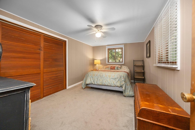 carpeted bedroom with ceiling fan and a closet