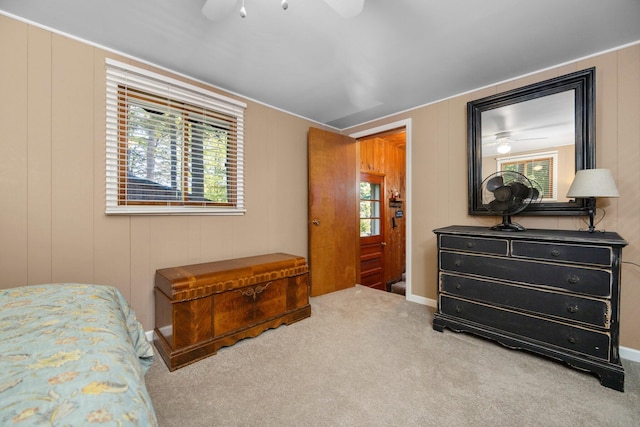 bedroom with carpet, ceiling fan, and wooden walls