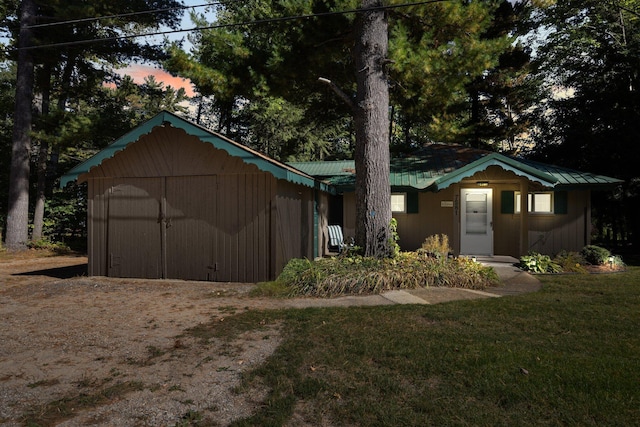 view of front of property featuring a yard and a storage shed