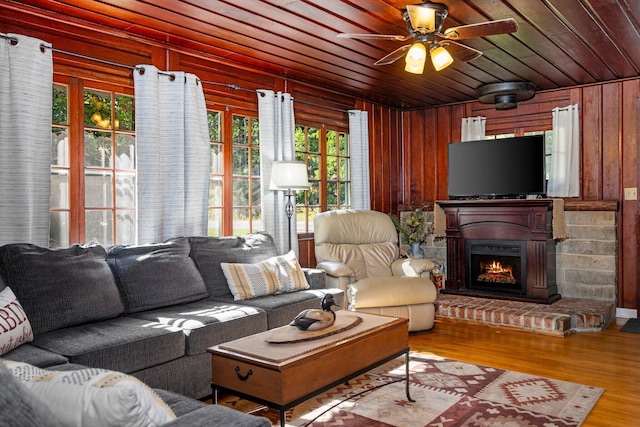 living room with hardwood / wood-style floors, ceiling fan, wood walls, and wooden ceiling