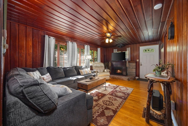 living room featuring hardwood / wood-style floors, ceiling fan, wooden walls, and wood ceiling