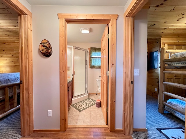 hallway with wood walls and hardwood / wood-style floors