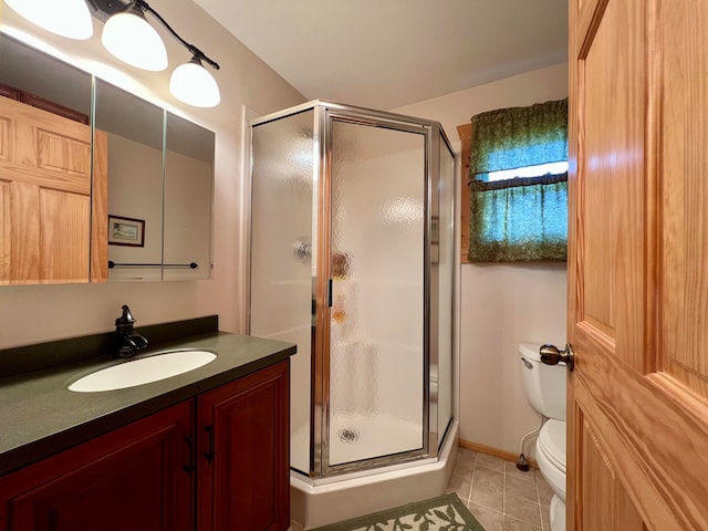 bathroom with walk in shower, vanity, toilet, and tile patterned floors