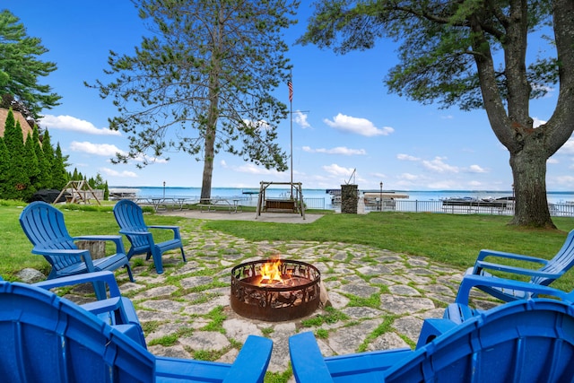 view of yard with a water view, a patio area, and a fire pit