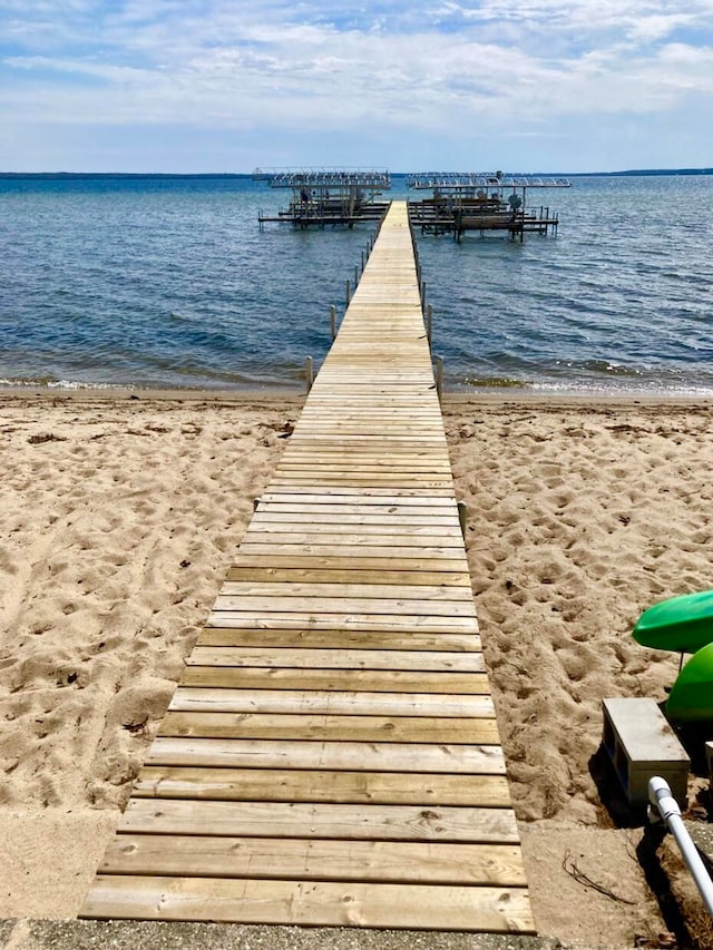 view of dock with a view of the beach and a water view