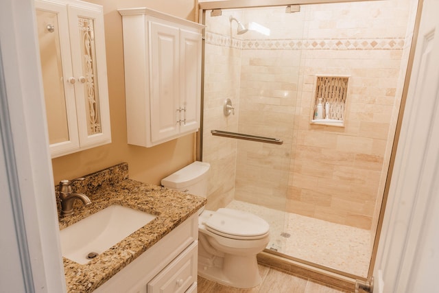 bathroom with walk in shower, vanity, and toilet