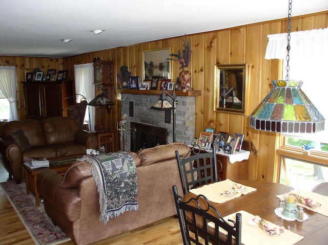 living room featuring wooden walls, a fireplace, and light hardwood / wood-style flooring