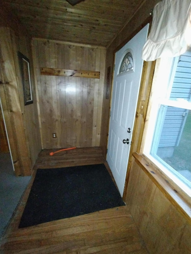 hallway featuring hardwood / wood-style flooring, wood walls, and wood ceiling