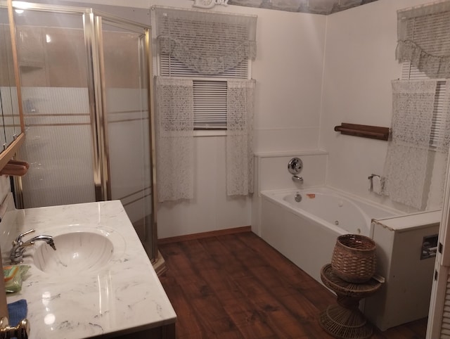 bathroom with separate shower and tub, vanity, and hardwood / wood-style flooring