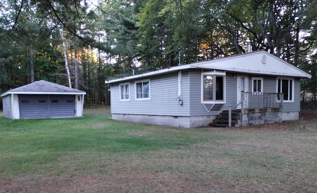 view of front of home featuring an outbuilding, a front yard, and a garage