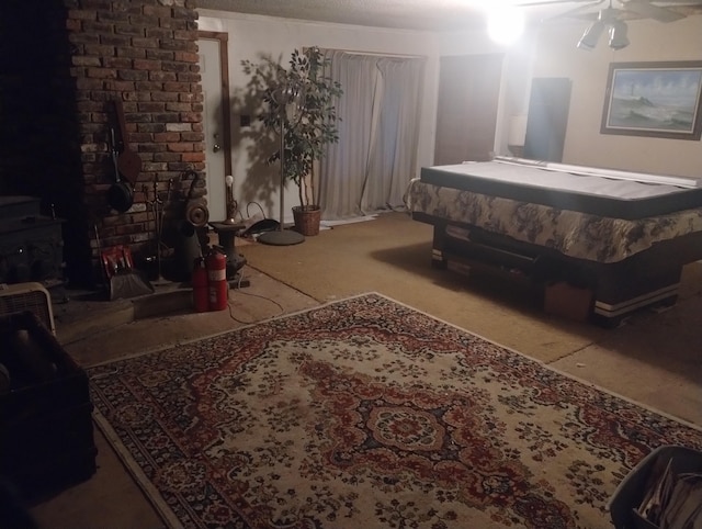 bedroom featuring a wood stove, ceiling fan, and carpet floors