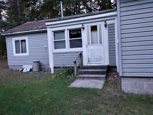 doorway to property with a lawn