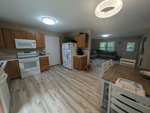 kitchen featuring white appliances and light hardwood / wood-style flooring